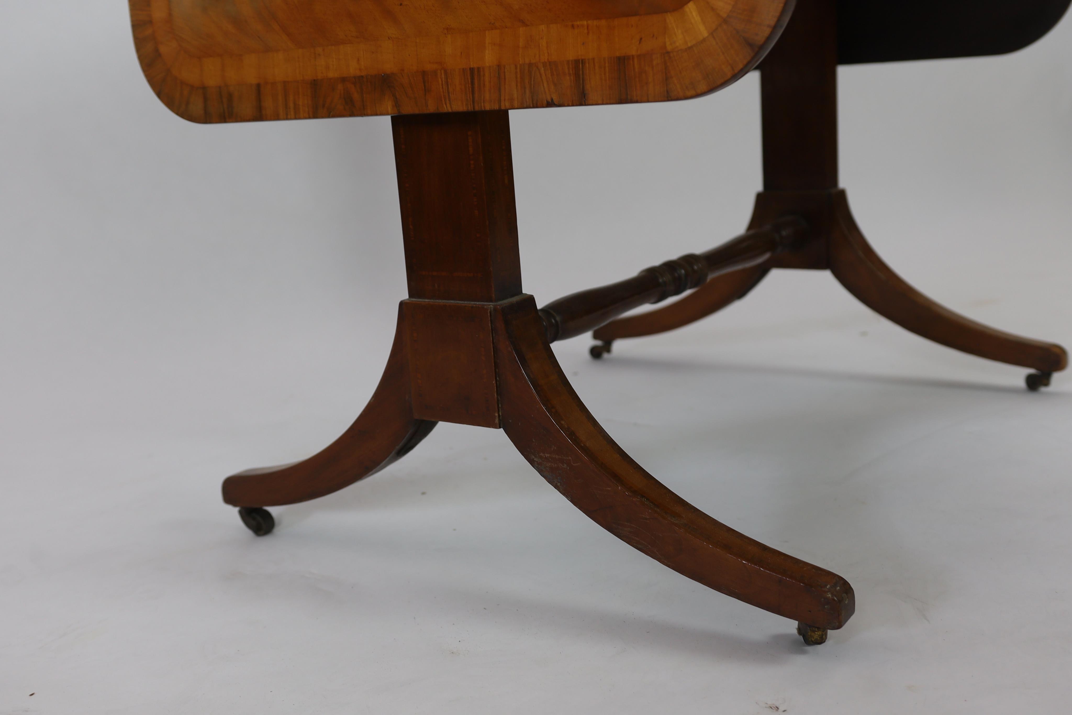 A Regency satinwood banded mahogany sofa table, with two frieze drawers on end standards with turned stretcher and downswept legs, fitted brass castors, width 80cm, depth 64cm, height 71cm. Condition - fair